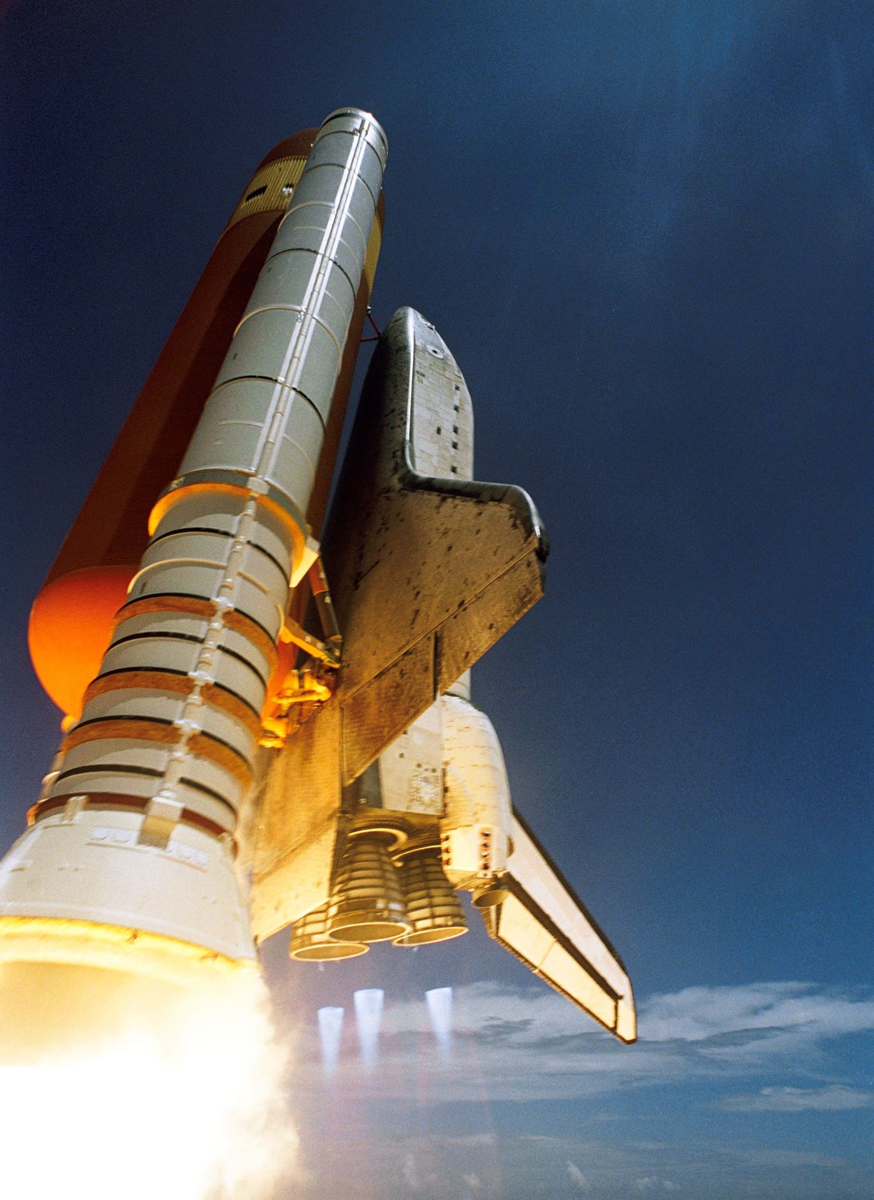 Space shuttle and launch vehicle lifting off
